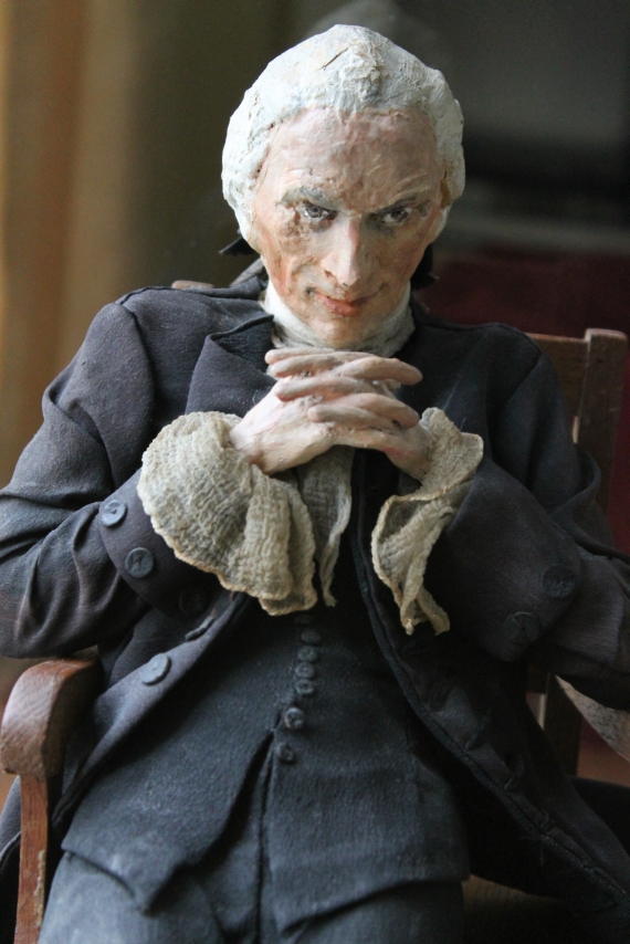 small model of laurence sterne sitting, feet crossed at the ankles